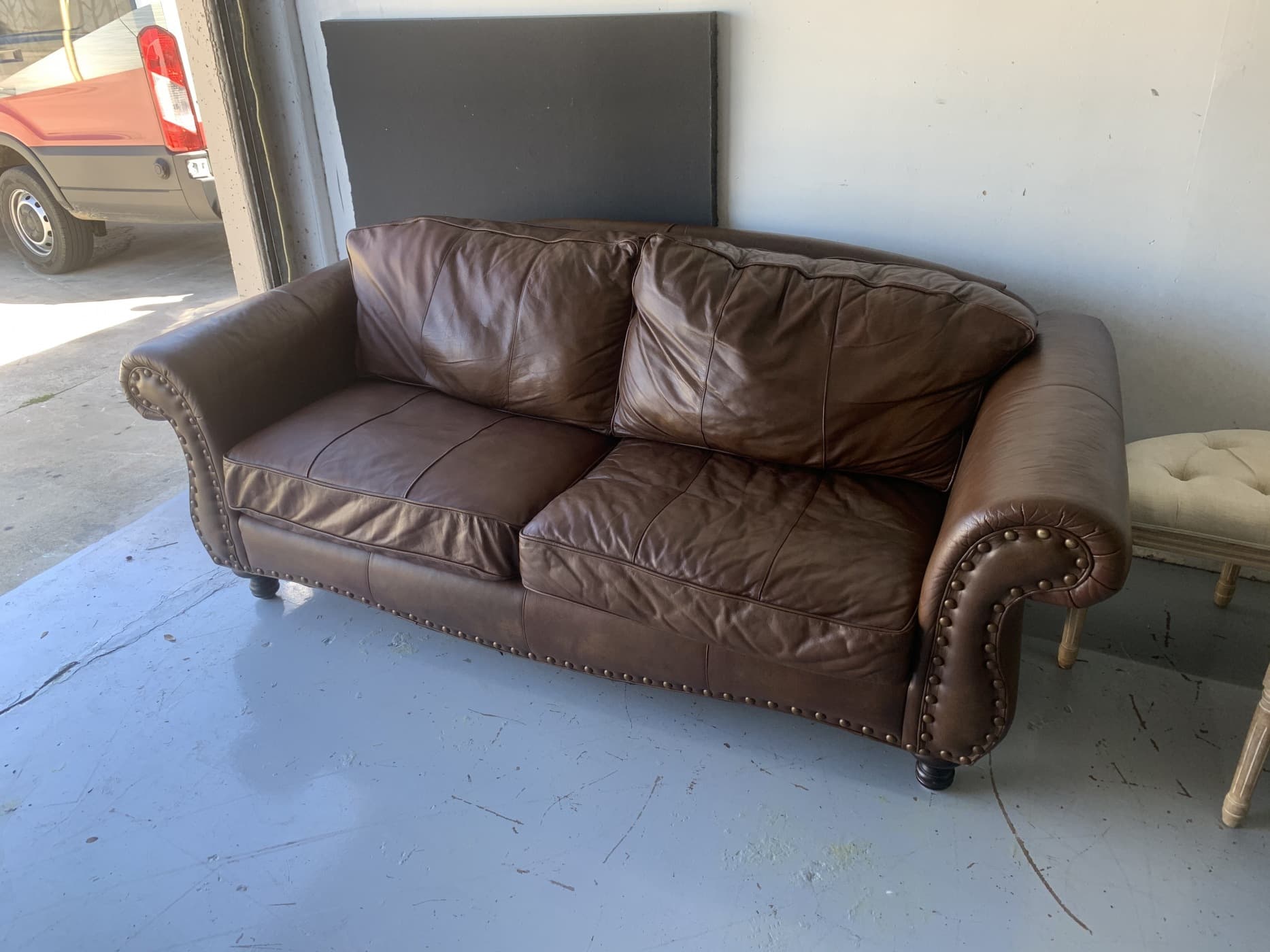 Brown leather loveseat after seat cushion rebuild — restored comfort and shape