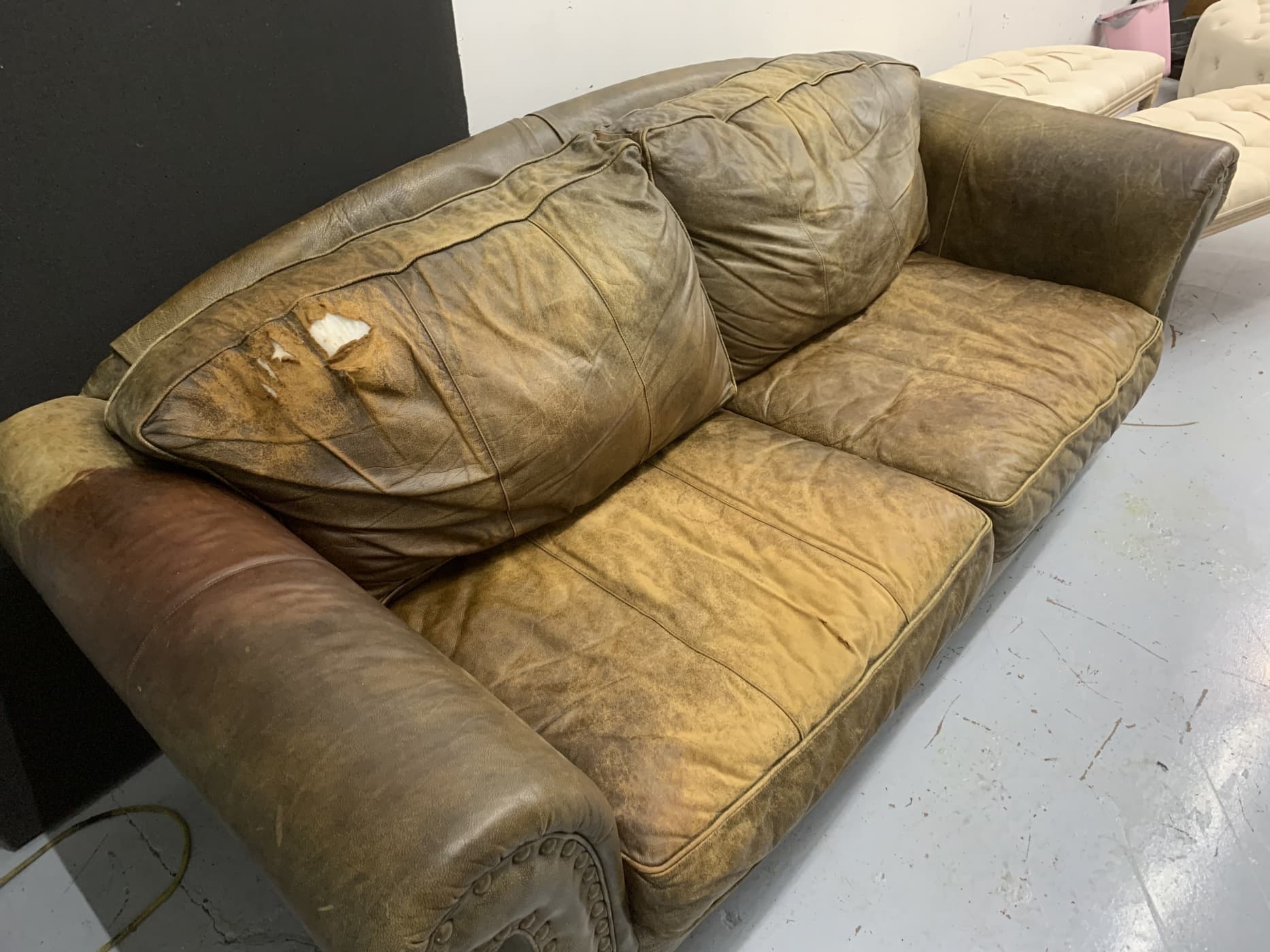 Brown leather loveseat before cushion rebuild — collapsed and damaged seat cushion
