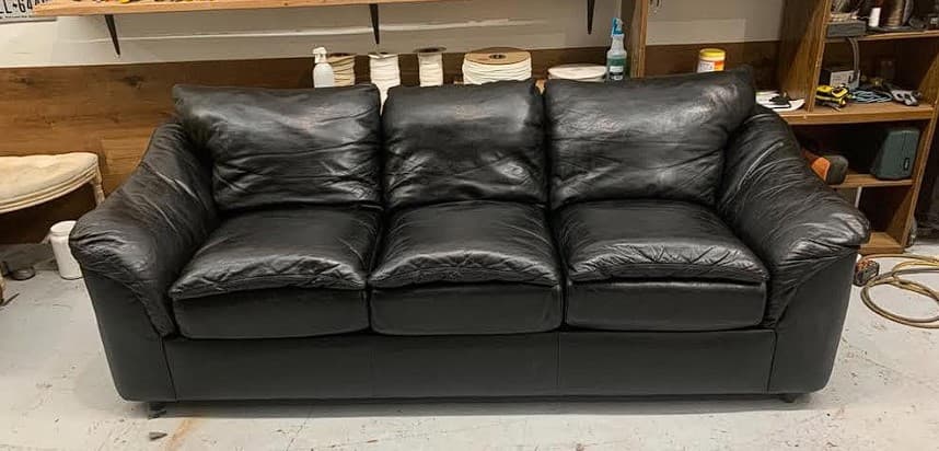 Black leather sofa after professional scratch repair and restoration in Philadelphia PA