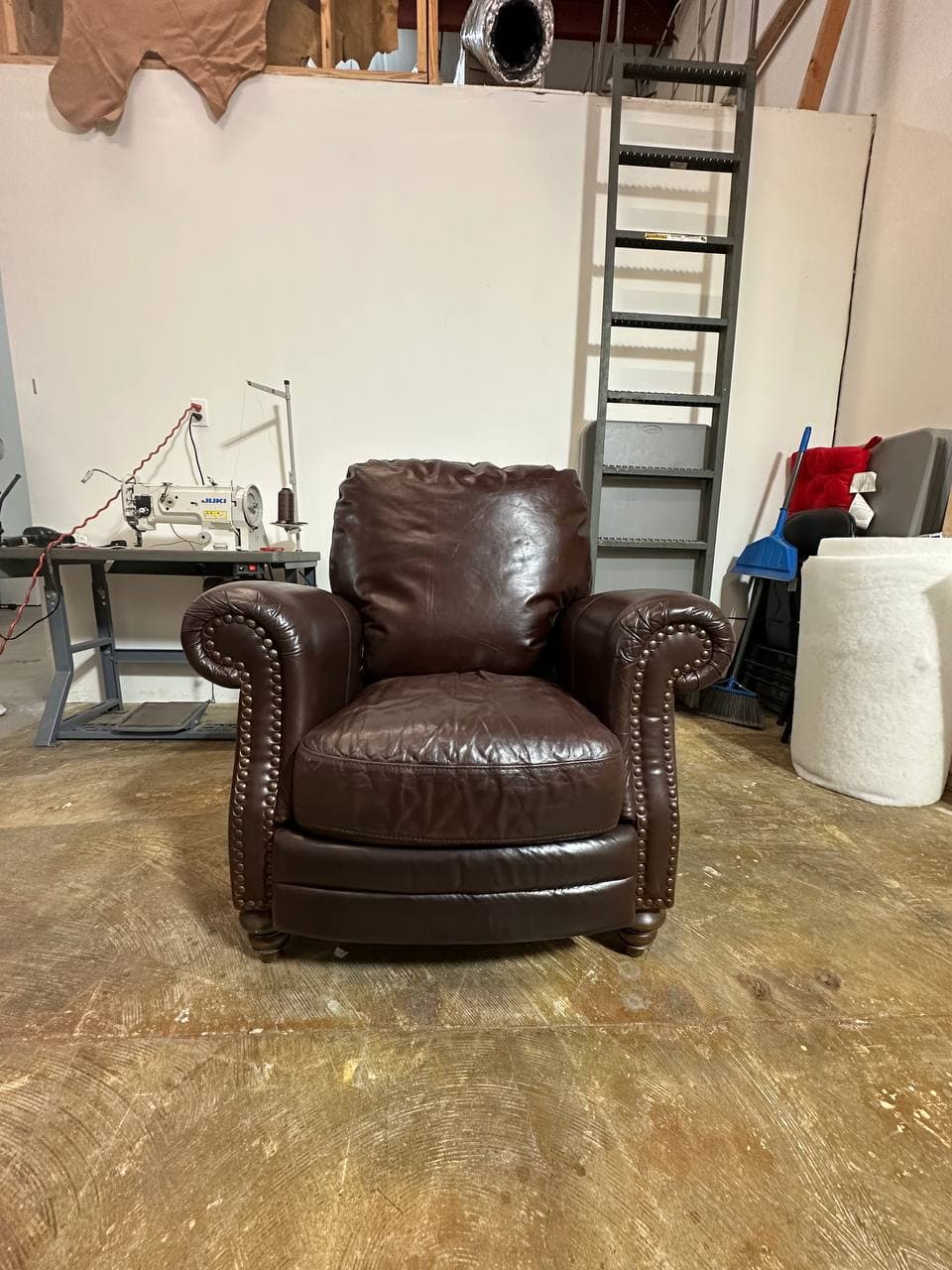 Brown leather recliner after professional restoration — reconstructed back cushion, renewed leather color and finish