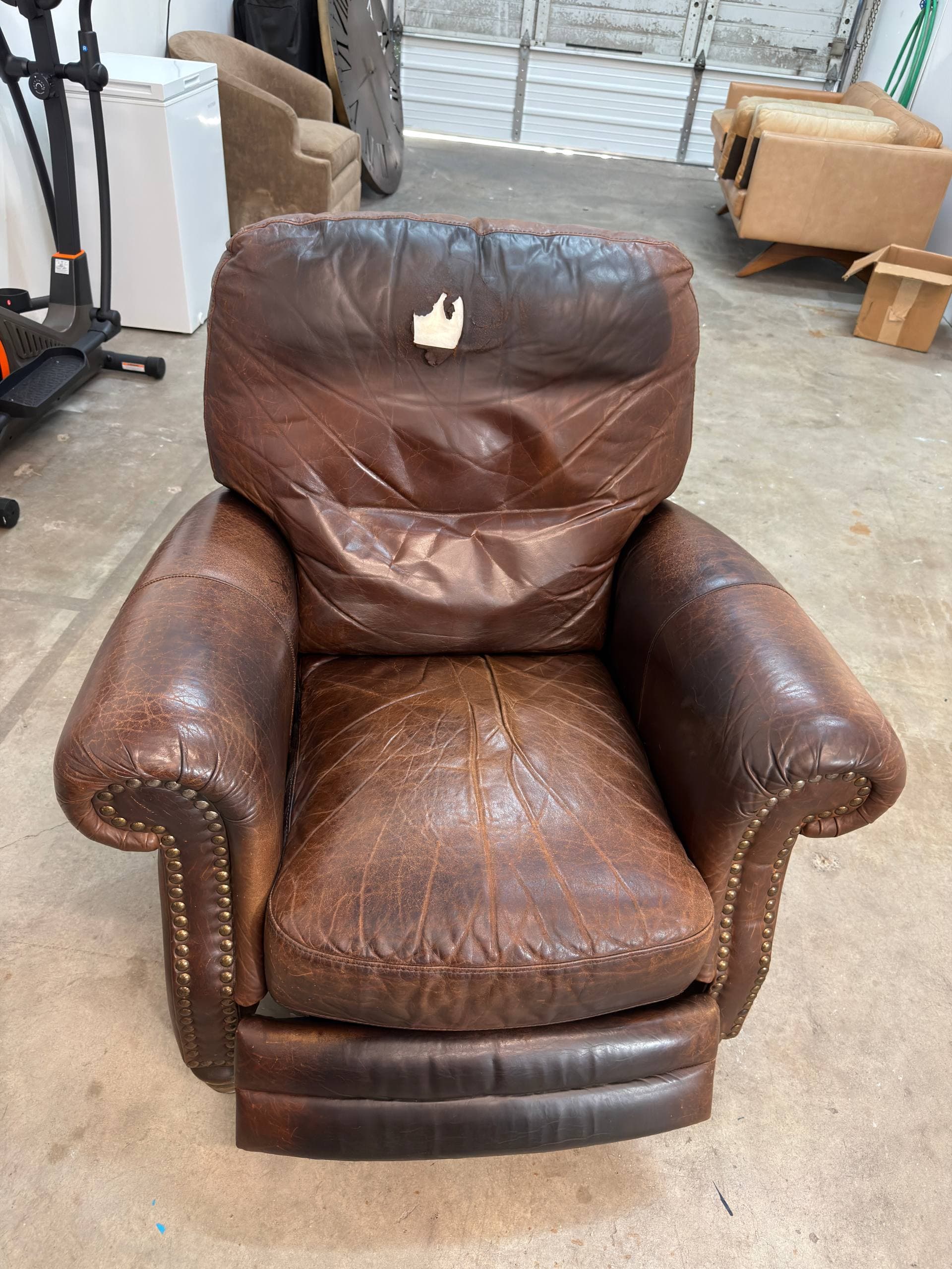 Brown leather recliner before restoration — worn leather, faded finish, and damaged back cushion from years of daily use
